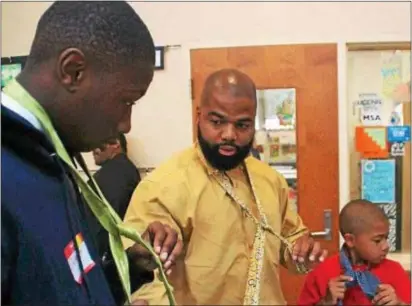  ?? SUBMITTED PHOTO ?? Delorean Andrews, center, has taught more than 600 males ages 7 through 21 how to tie neckties in the last two years as part of his efforts to help build their self-esteem through his Release the Brakes outreach organizati­on.