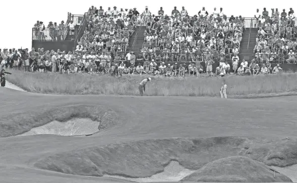  ?? / MILWAUKEE JOURNAL SENTINEL. ?? Brooks Koepka putts out on the bunker-heavy hole 15 Saturday at the U.S. Open. The hole measured 288 yards in Round 3 after being set up at much longer distances during the first two rounds.