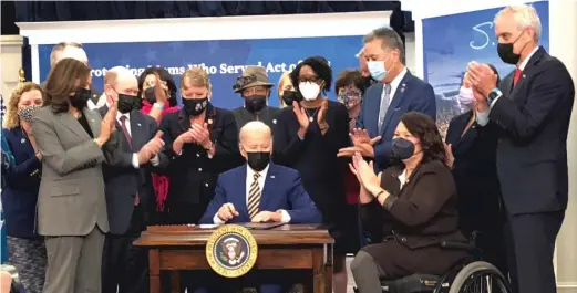  ?? LYNN SWEET/SUN-TIMES ?? Applauding President Joe Biden signing their “Protecting Moms Who Served Act of 2021” are, to Biden’s right, Illinois Democrats Rep. Lauren Underwood and Sen. Tammy Duckworth.