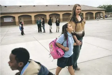  ?? DAVID WALLACE/THE REPUBLIC ?? Shantel and Angelina Rocha walk on campus at the Arts Academy at Estrella Mountain in Tolleson. Rocha had looked forward to volunteeri­ng in the classroom and attending parent-teacher conference­s.