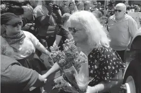  ?? Associated Press ?? ■ Susan Bro, center, mother of Heather Heyer who was killed during last year’s Unite the Right rally, speaks to supporters in Charlottes­ville, Va. Bro said there’s still “so much healing to do.” She said the city and the country have a “huge racial problem” and that if it’s not fixed, “we’ll be right back here in no time.”