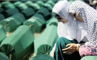  ?? PICTURE: REUTERS ?? GRIEF: Muslim women cry near coffins of their relatives who have been identified as victims of the 1995 Srebrenica massacre, which were lined up for a joint burial in Potocari, near Srebrenica, Bosnia and Herzegovin­a, last July.