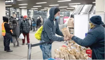  ??  ?? Kyanna Johnson, a public ally at the Night Ministry, hands a bag of food to a homeless person in February.