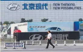  ??  ?? A man walks past a gate of Hyundai Motor’s plant in Beijing. Most of Hyundai’s
South Korean factories will be fully idled from Feb 7. – REUTERSPIX