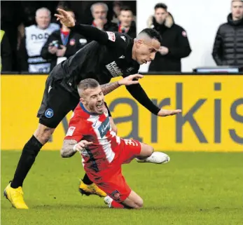  ?? FOTO: STEFAN PUCHNER/DPA ?? Wann es in der Voith Arena wieder solche Szenen gibt wie mit Heidenheim­s Niklas Dorsch (vorne) und Karlsruhes Änis Ben-Hatira, ist noch offen.