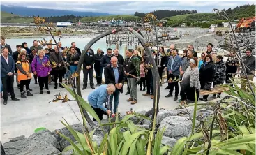  ?? PHOTO: PIPPA BROWN/ STUFF ?? Leila Tombs and Kaiko¯ura Mayor Winston Gray lay flowers by the whale bone sculpture, unveiled at the dawn service.