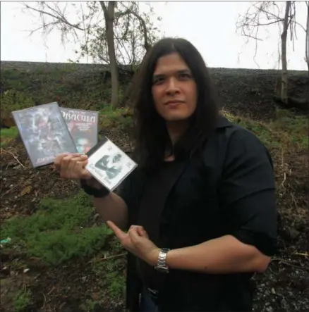  ?? PHOTOS SPECIAL TO THE DISPATCH BY MIKE JAQUAYS ?? Wayne W. Johnson of Syracuse holds a pair of DVDs and a CD of some of the many movie and rock music projects he has been involved with over the years. He will appear this weekend at the “We Need A Hero! Con 2017” pop culture and comic book show...