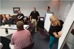  ?? Staff photo by Joshua Boucher ?? n Tracy Riffe, a Federal Bureau of Investigat­ion support staff member, writes down a list of steps to take to respond to a simulated child abduction at the Troop G State Police station in Hope, Ark. The simulation, which involved state police, the FBI,...