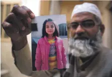  ?? AP ?? Mohammed Ansari with the picture of his seven-year-old daughter Zainab, whose murder caused outrage. He has called for her murderer to be hanged in a public place