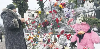  ?? Picture: AFP ?? REMEMBERED. A woman places flowers outside the Russian Embassy in Kiev yesterday, in tribute to the victims of a shopping mall fire in the Siberian coal-mining city of Kemerovo. At least 64 people died.