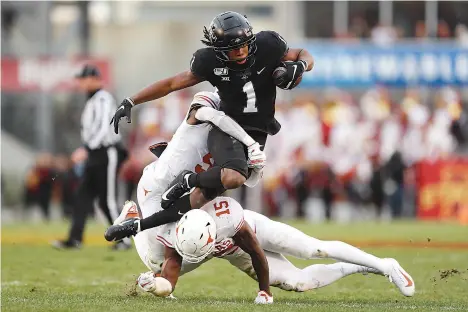 ?? AP Photo/Charlie Neibergall ?? ■ Iowa State wide receiver Tarique Milton (1) is tackled by Texas defenders D'Shawn Jamison, left, and Chris Brown after catching a pass during the first half of an NCAA college football game Saturday in Ames, Iowa.