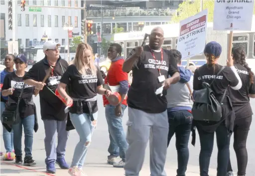  ?? ELIZA DAVIDSON/SUN-TIMES ?? Striking hotel workers picket Tuesday outside the Wyndham Grand.