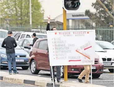  ?? PICTURES: ANTOINE DE RAS ?? KNOWLEDGE IS POWER: Bedfordvie­w, Kensington and Edenvale residents take part in an awareness campaign about window washers at the intersecti­on of Marcia and Albertina Sisulu streets in Bruma.