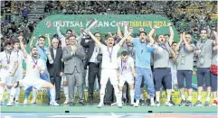  ?? ?? Iranian team players and officials celebrate with the AFC Asian Cup futsal trophy on Sunday night.