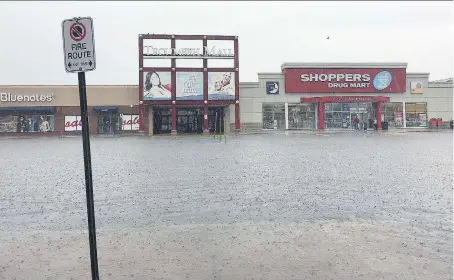  ?? PHOTOS: DAN JANISSE ?? A flooded parking lot at the Tecumseh Mall prompted management to close the mall for the day Thursday.