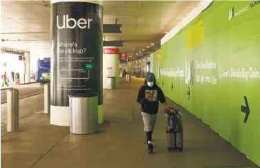  ?? Patrick T. Fallon / New York Times ?? A traveler walks toward an Uber pickup space at Los Angeles Internatio­nal Airport last month.