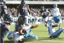  ?? CHRIS SWEDA / CHICAGO TRIBUNE ?? Bears quarterbac­k Justin Fields (1) runs over Lions safety DeShon Elliott (5) to score a touchdown at Soldier Field.