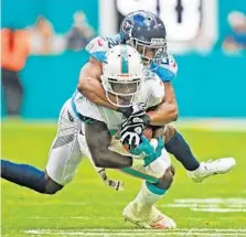  ??  ?? Miami receiver Jakeem Grant hauls in a pass in the third quarter against the Titans’ Logan Ryan. Grant had five catches for 38 yards and also had a 102-yard kickoff return for a touchdown.