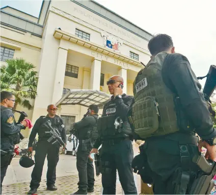  ?? SUNSTAR FOTO / ALAN TANGCAWAN ?? THREAT RESPONSE. Members of the Special Weapons and Tactics team checked the City Hall premises following a bomb threat that was sent to the mobile phones of employees and officials.