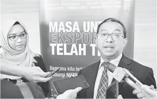 ??  ?? TEROKA PASARAN HALAL: Khairul (kanan) bercakap kepada pemberita di Kuching semalam. Turut kelihatan Pengarah MATRADE Sarawak Leany Mokhtar.