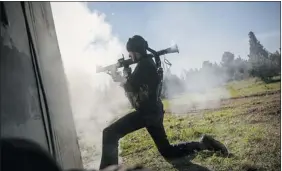  ?? The Associated Press ?? A Free Syrian Army fighter fires a weapon Saturday during fighting north of Aleppo, Syria.
The rebels took control of a military academy after several hours of fighting.