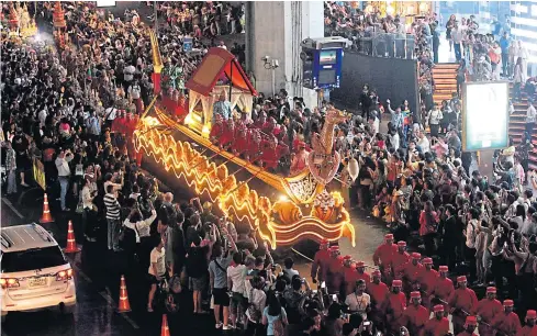  ?? SEKSAN ROJJANAMET­AKUN ?? A float depicting the ornate Suphannaho­ng royal barge is pulled through the streets of central Bangkok as part of the “Discover Thainess” parade staged by the Tourism Authority of Thailand yesterday. The event is being held until Sunday to promote...