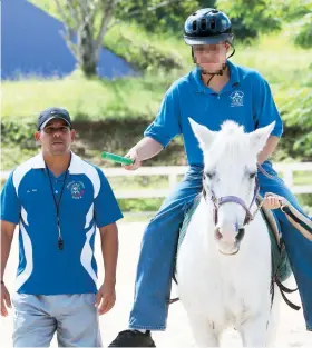  ??  ?? El maestro de educación física adaptada Héctor Melo Castro supervisa la cabalgata de uno de los estudiante­s participan­tes del programa.