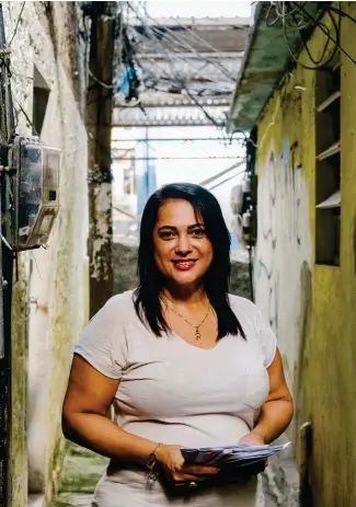  ??  ?? Eliane Ramos Vieira da Silva, la creadora de Carteiro Amigo,
en una de las callejuela­s de las favelas de Río.