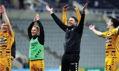  ?? Photograph: Owen Humphreys/PA ?? Mark Bonner and his Cambridge United players celebrate in front of their fans after their stunning win at Newcastle.