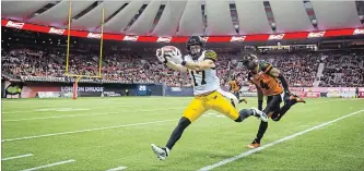  ?? DARRYL DYCK THE CANADIAN PRESS ?? Luke Tasker hauls in a pass in front of B.C. Lions’ Garry Peters (4) during the second half of Saturday’s loss in Vancouver.