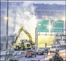  ?? JOHN SPINK /JSPINK@AJC.COM ?? Atlanta firefighte­rs remained on the scene in northeast Atlanta putting out a smoldering fire Friday at the I-85 collapse site while constructi­on crews made their way into the zone to begin work.