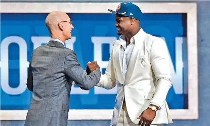  ?? AFP ?? Sonriente, Zion Williamson (der.) estrechó la mano del comisionad­o Adam Silver.