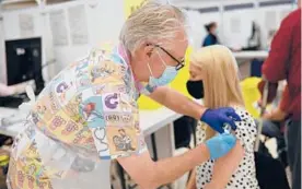  ?? OLI SCARFF/AFP ?? A health worker administer­s a COVID-19 vaccine Wednesday in Derbyshire, England. Seven people in the U.K. have died from clots after getting the AstraZenec­a shot.