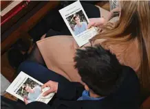  ?? Pool/Getty Images ?? Loved ones hold programs during the funeral Mass for Brian Fraser at St. Paul on the Lake Catholic Church.