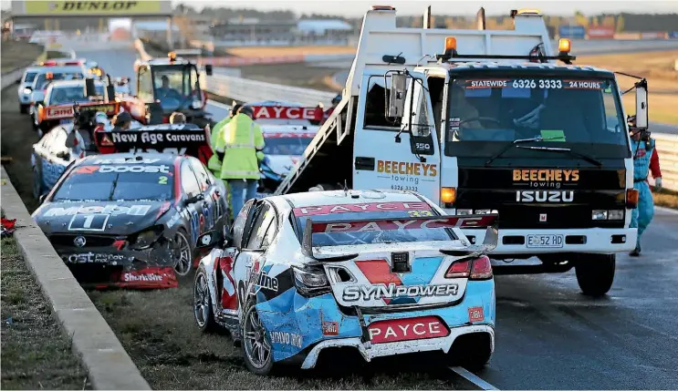  ??  ?? Road crews attend the carnage at Symmons Plains Raceway in Tasmania yesterday after a huge crash.