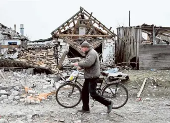  ?? AFP ?? Toll of war: A resident walks past the destroyed private houses in the village of Velyka Pysarivka, which lies five kilometres from the Russian border, in Sumy region, amid the Russian invasion of Ukraine.