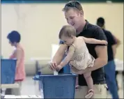  ?? Christina Ryan, Calgary Herald ?? Seventeen-month-old Avery Buchner helps her dad, Andrew, cast his vote Monday at the Huntington Hills community centre in the city’s northwest.