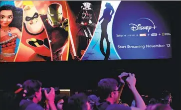  ?? Robyn Beck AFP/Getty Images ?? THE DISNEY+ booth draws a crowd at a Disney fan event in Anaheim in August. Cowen & Co. estimated that 6% of Netflix subscriber­s who signed up for Disney+ canceled their Netflix membership­s after doing so.