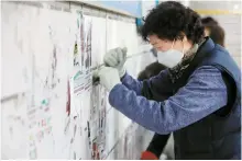  ?? Newsis ?? A cleaning worker removes posters from the wall at a subway station in Seoul, in this February 2023 photo.