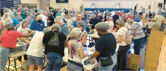  ?? FOOD FOR THE POOR/COURTESY PHOTOS ?? More than 450 volunteers filled FAU Arena to help Food For The Poor pack 116,640 lifesaving MannaPack rice meals for children and families in desperate need in Ukraine. The event drew South Florida churches, businesses, community groups and civic-minded individual­s.