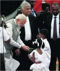  ?? Reuters ?? Narendra Modi is greeted by children in Katunayake as Sri Lankan prime minister Ranil Wickremesi­nghe looks on.