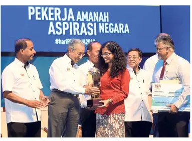  ??  ?? Proud moment:
Dr Mahathir presenting the award to Sandhya during the Labour Day celebratio­n at Putrajaya Internatio­nal Convention Centre. Looking on is Kulasegara­n (left).