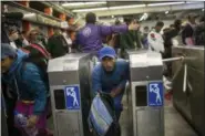  ?? RODRIGO ABD — THE ASSOCIATED PRESS ?? A Central American migrant bypasses a subway turnstile after leaving the temporary shelter at the Jesus Martinez stadium, in Mexico City, Friday. About 500 Central American migrants headed out of Mexico City on Friday to embark on the longest and most dangerous leg of their journey to the U.S. border, while thousands more were waiting one day more at the stadium.