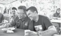  ?? — Gambar Bernama ?? RAMAH MESRA: Abdul Rahman (dua kanan) beramah mesra bersama pencabarny­a Azis (kanan) ketika hadir pada majlis kenduri semasa berkempen bagi Pilihan Raya Umum Ke-14 di Kampung Darau Lama, Menggatal, semalam.