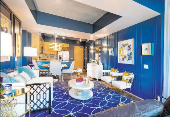  ?? Lee Bryan Interior Design ?? Designer Lee Bryan likes to incorporat­e a design element that ties elements together, such as this blue wall color that he used in this Juhl high-rise model.