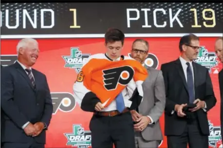  ?? MICHAEL AINSWORTH — THE ASSOCIATED PRESS ?? Jay O’Brien, second from left, puts on a Flyers jersey after being selected No. 19 overall in the first round by the Flyers Friday night in Dallas.