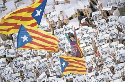  ?? Emilio Morenatti/Associated Press ?? Protesters hold signs reading “Freedom for the two Jordis” during a march Saturday in Barcelona, Spain, to protest the National Court's decision to imprison civil society leaders. The Spanish government moved decisively Saturday to use a previously untapped constituti­onal power so it can take control of Catalonia and derail the independen­ce movement.