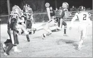  ?? Westside Eagle Observer/MIKE ECKELS ?? Sam Philpott (Decatur 13) tries to slip a Wolverine defender’s tackle as he heads to the goal line during the Decatur-Western Yell eight-man football contest in Decatur Friday night. Philpott managed another 20 yards before the Wolverine defense brought him down just shy of the goal line.