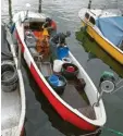  ??  ?? Das Boot fertigmach­en, raus aufs Wasser, dann die Netze einholen – das machen Vater und Sohn fast jeden Tag.