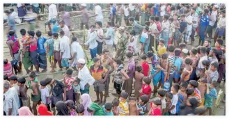  ??  ?? In this Sept. 25 file photo, Rohingya Muslims, who crossed over from Myanmar into Bangladesh, wait to receive aid during its distributi­on near Balukhali refugee camp, Bangladesh. (AP)